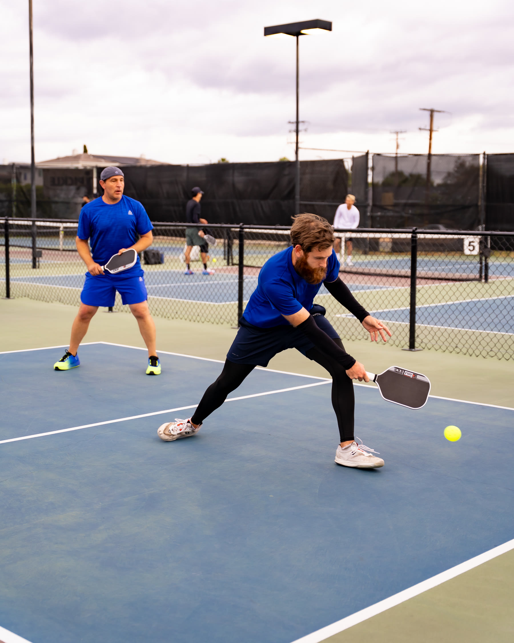 Oliver Lynch competing in doubles on an outdoor pickleball court